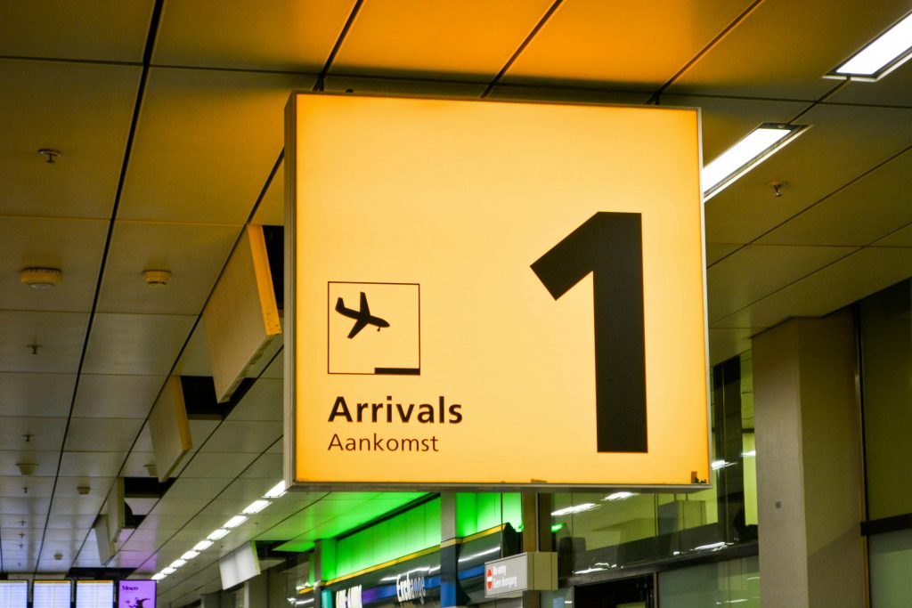 Airport Transfers 15 Bright arrivals sign with airplane symbol in an airport terminal.